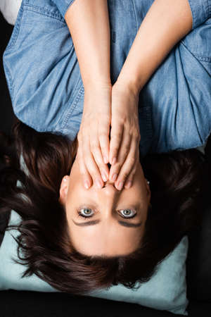 top view of terrified brunette woman covering mouth
