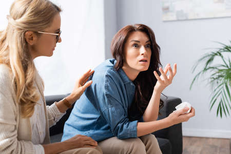 blonde woman therapist calming patient during treatmentの写真素材