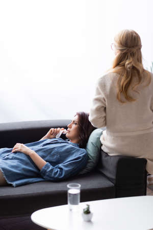 brunette woman with mental problem visiting therapistの写真素材