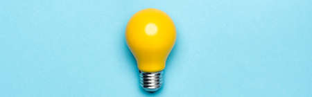 top view yellow light bulb on blue background, banner