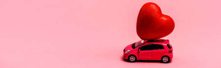 toy car and red heart on pink background, bannerの写真素材