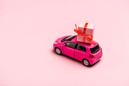 toy car and gift box on pink backgroundの写真素材