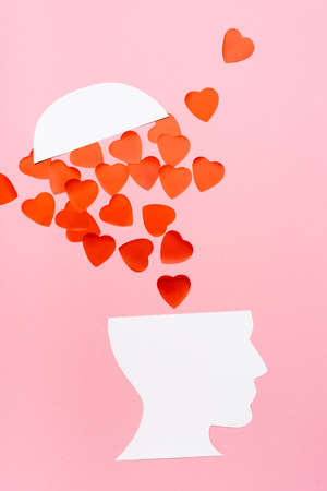 top view of paper human head and heart on pink backgroundの写真素材