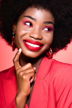 happy african american young woman in stylish outfit isolated on redの写真素材