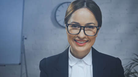 Smiling insurance agent looking at camera in officeの写真素材