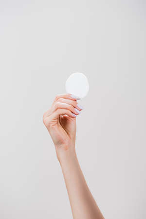 cropped view of woman holding cotton pad isolated on grayの写真素材