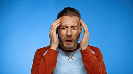 disgusted young man with closed eyes on blue