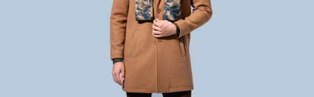 cropped view of trendy man in winter coat isolated on gray, banner