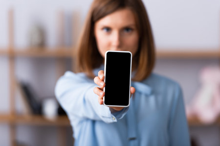 Smartphone with blank screen in hand of blurred psychologist on backgroundの写真素材