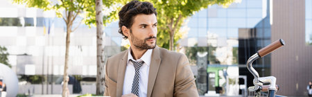 businessman in suit looking away near bike, bannerの写真素材