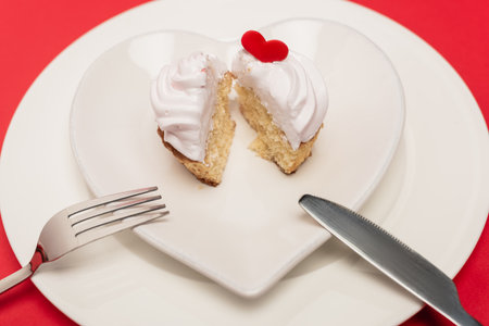 cupcake on plate with cutlery on red background