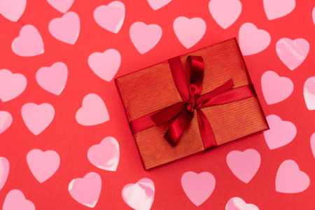 top view of pink hearts and gift box on red backgroundの写真素材