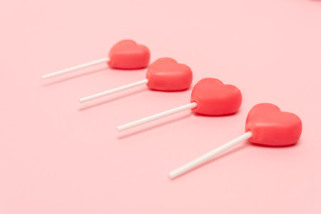 heart shaped lollipops on pink backgroundの写真素材