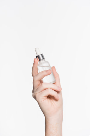 cropped view of female hand with serum on shoulder isolated on whiteの写真素材