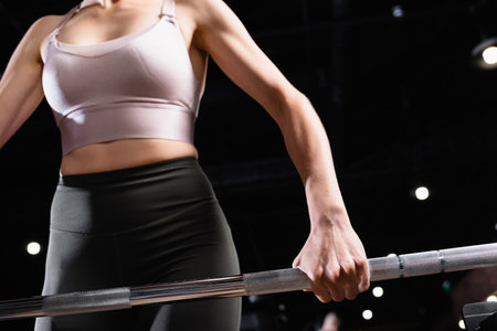 cropped view of athletic sportswoman lifting power rack in sports centerの写真素材