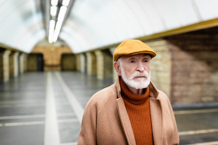 elderly man in autumn cap and coat at metro station