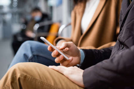 cropped view of man using smartphone in subwayの写真素材