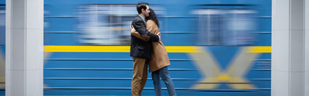 motion blur of interactional couple hugging near wagon in subway, banner