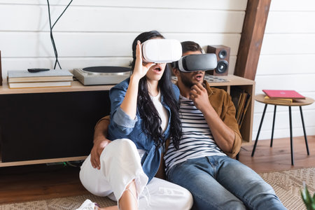 amazed man hugging girlfriend while gaming in vr headsets together on floor