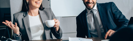 Cropped view of smiling businesspeople with coffee in office, banner