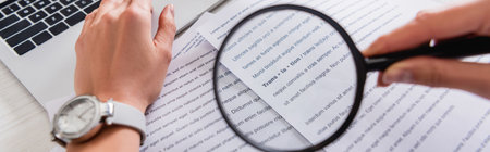 cropped view of translator holding magnifying glass near documents with english text, bannerの写真素材