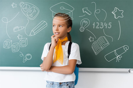 Schoolgirl with backpack looking away near green chalkboard with school icons illustrationの写真素材