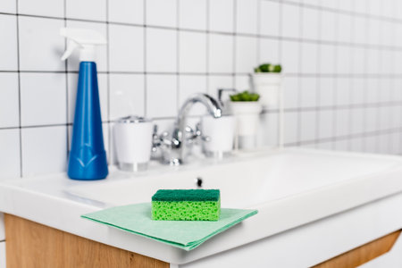 Sponge on rag near detergent on bathroom sink on blurred backgroundの写真素材
