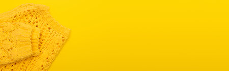 top view of knitted soft clothing isolated on yellow, banner
