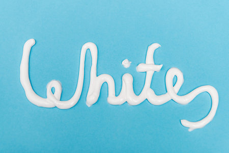 Top view of white lettering from toothpaste on blue backgroundの写真素材