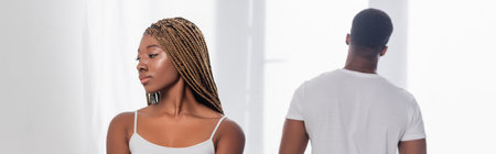 African american woman standing near boyfriend on blurred background at home, bannerの写真素材