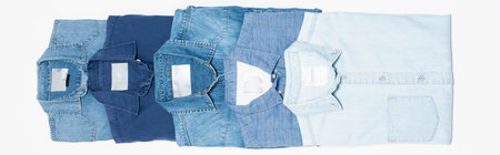 flat lay of different blue denim shirts on white, top view, bannerの写真素材