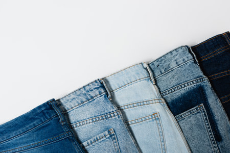 diagonal row of various jeans on white background, top viewの写真素材