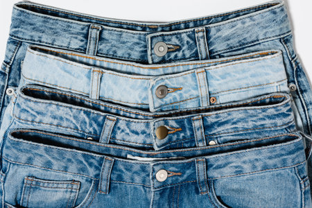 close up view of various blue jeans isolated on white, top view