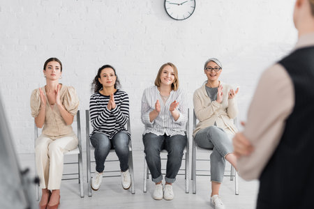 happy multicultural businesswomen applauding to speaker during seminarの写真素材