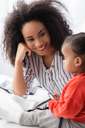 african american mother looking at daughter on blurred foregroundの写真素材