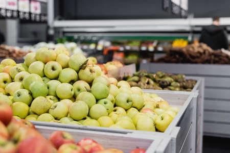 Fresh apples near groceries on blurred background in supermarketの写真素材