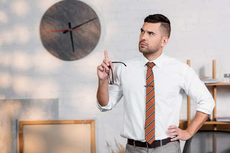 serious architect pointing with finger and looking away in officeの写真素材