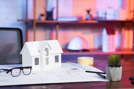 house model near blueprint and eyeglasses on desk in architectural agencyの写真素材