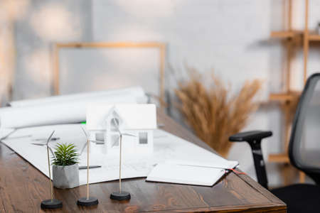 selective focus of wind turbines models near house maquette and blueprints on blurred backgroundの写真素材