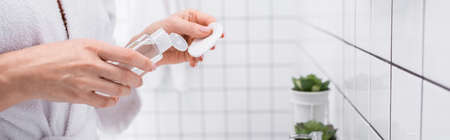 cropped view of woman holding toner and cotton pad in bathroom, bannerの写真素材