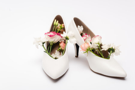 different flowers in female shoes on white backgroundの写真素材