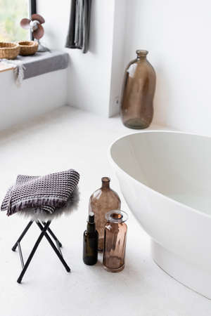 Decorative bottles near white bathtub at homeの写真素材