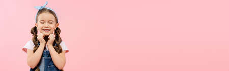 pleased kid with closed eyes smiling isolated on pink, banner