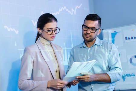 business people in glasses looking at documents in office