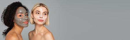 Interracial women in facial masks isolated on gray with copy space, banner