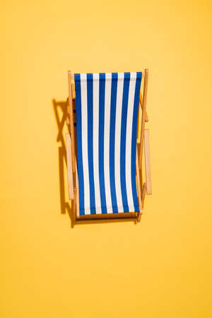 top view of striped deck chair on yellowの写真素材
