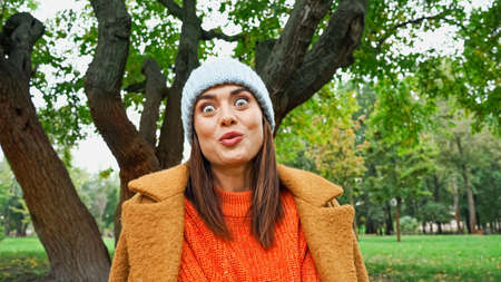 excited woman with crazy face expression looking at camera in park