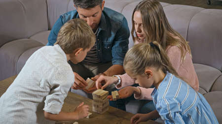 Family with kids playing wood blocks game at homeの写真素材