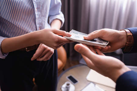 Cropped view of business partners holding dollars in restaurantの写真素材