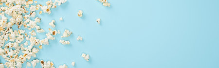 top view of salty popcorn scattered on blue, banner, cinema conceptの写真素材